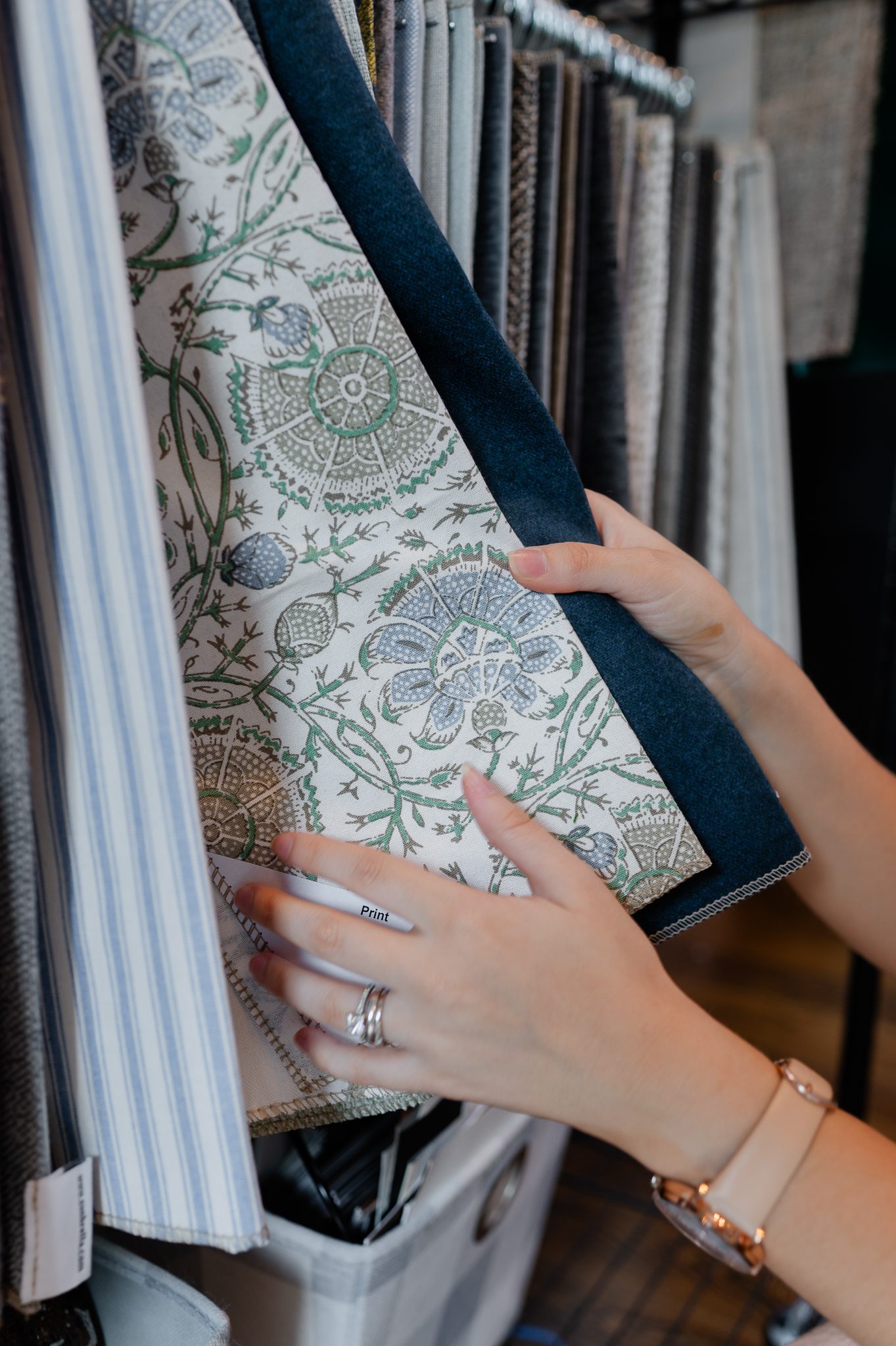 Interior designer browsing luxury patterned fabrics for custom home interiors.
