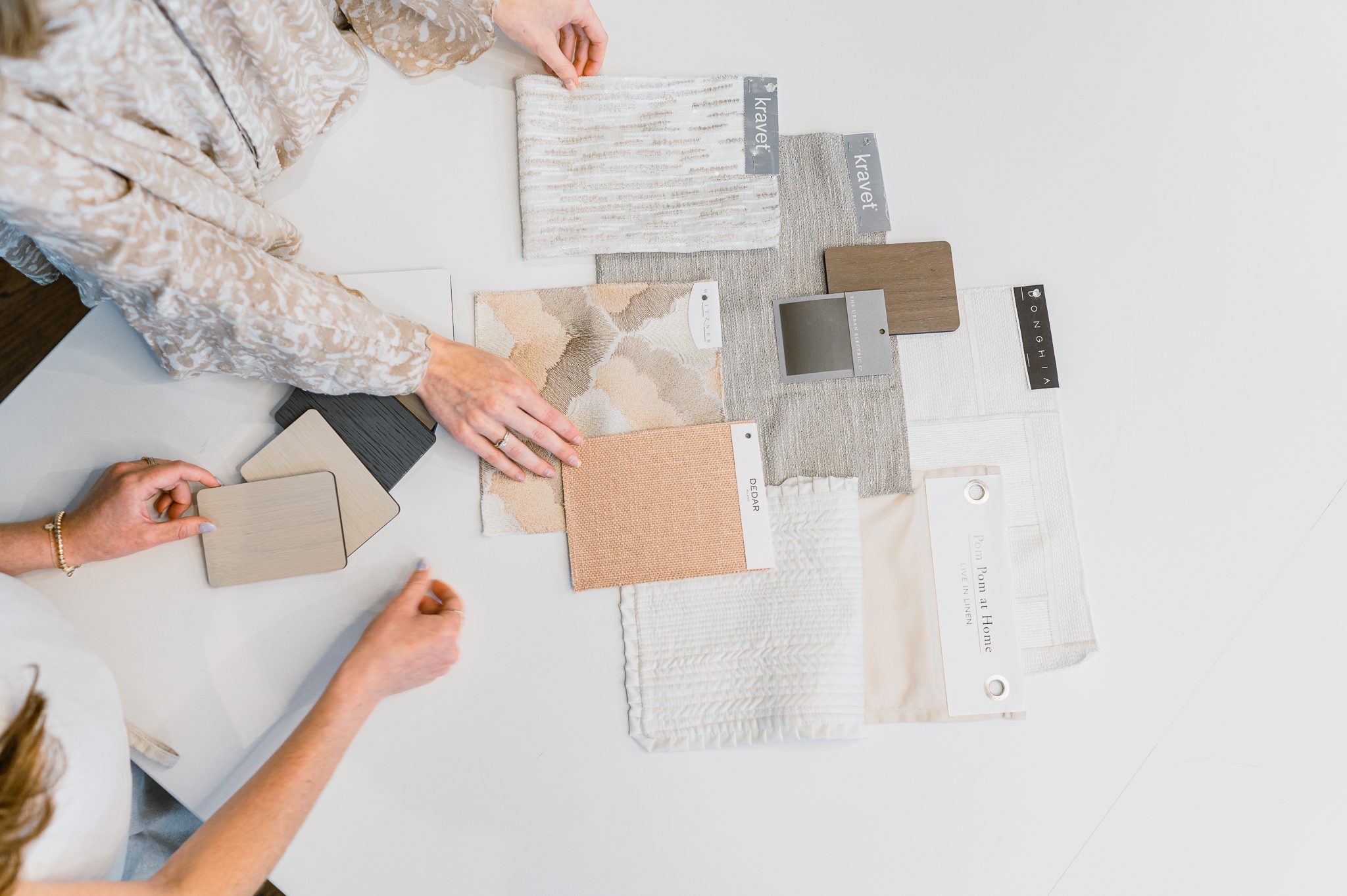 Material board with neutral fabric, tile, and surface samples for a custom renovation project.